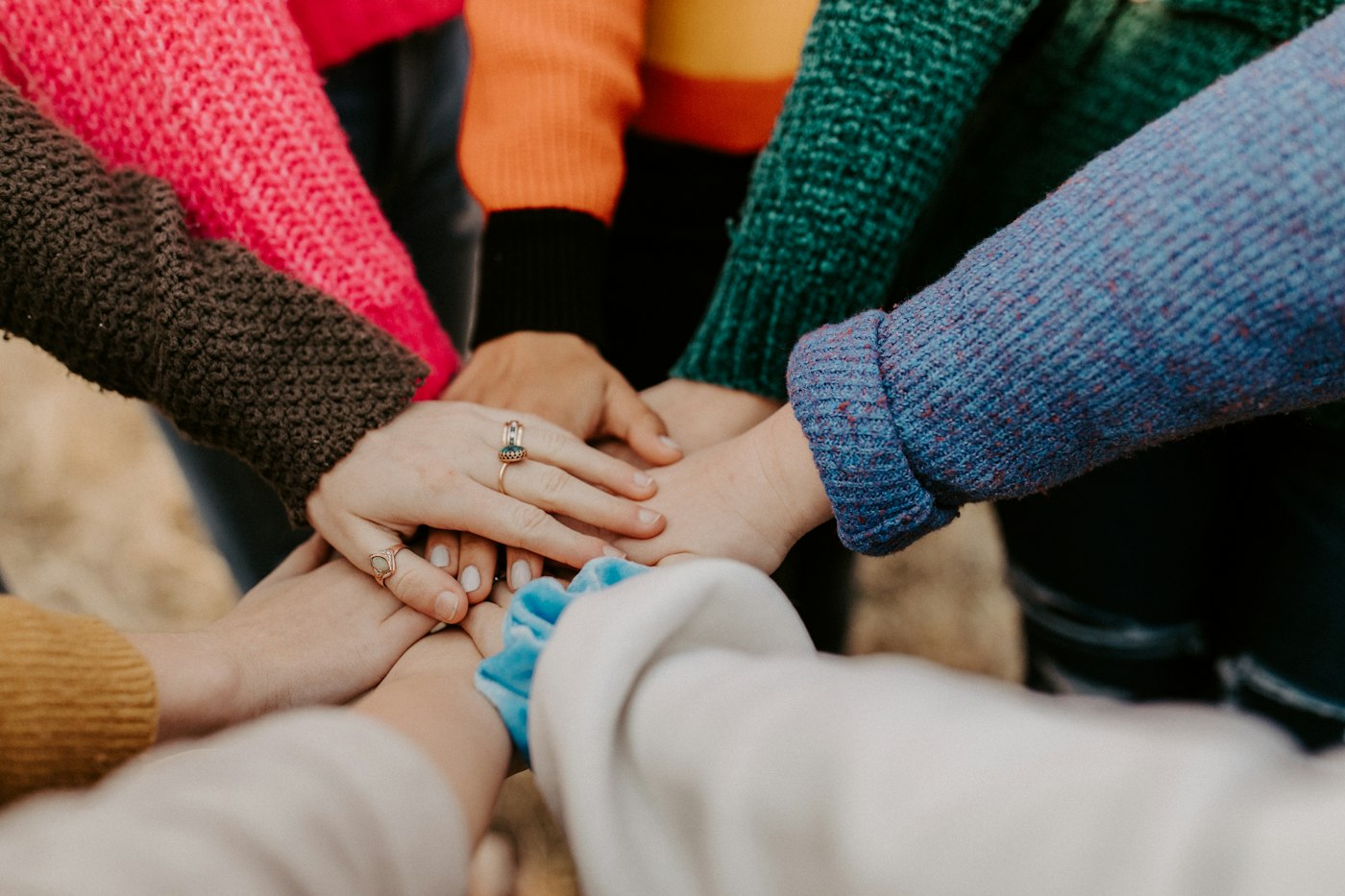 A circle of people resting their hands together